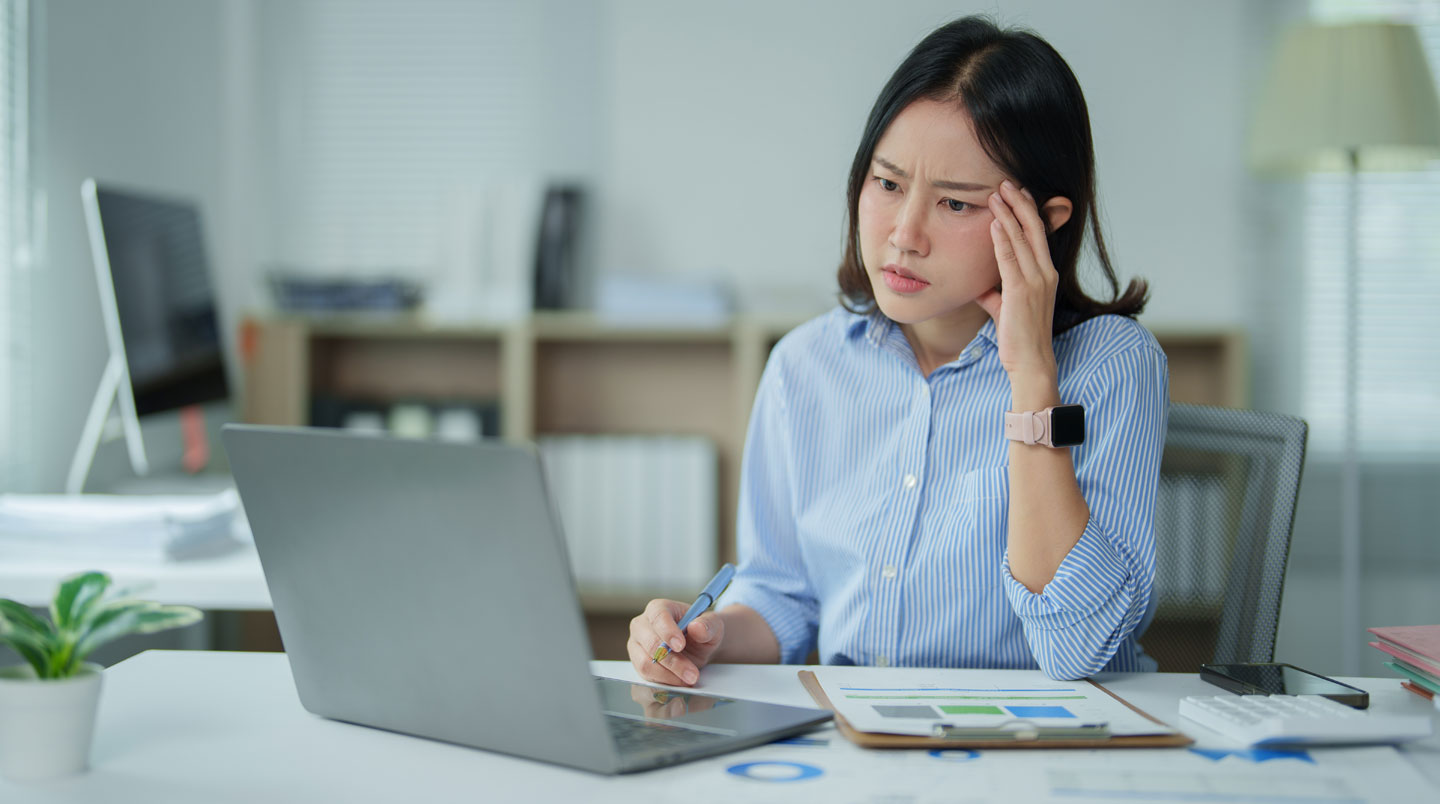 Une femme debout dans un loft lumineux, tenant un tableau de bord rempli de notes, symbolisant la gestion entrepreneuriale.